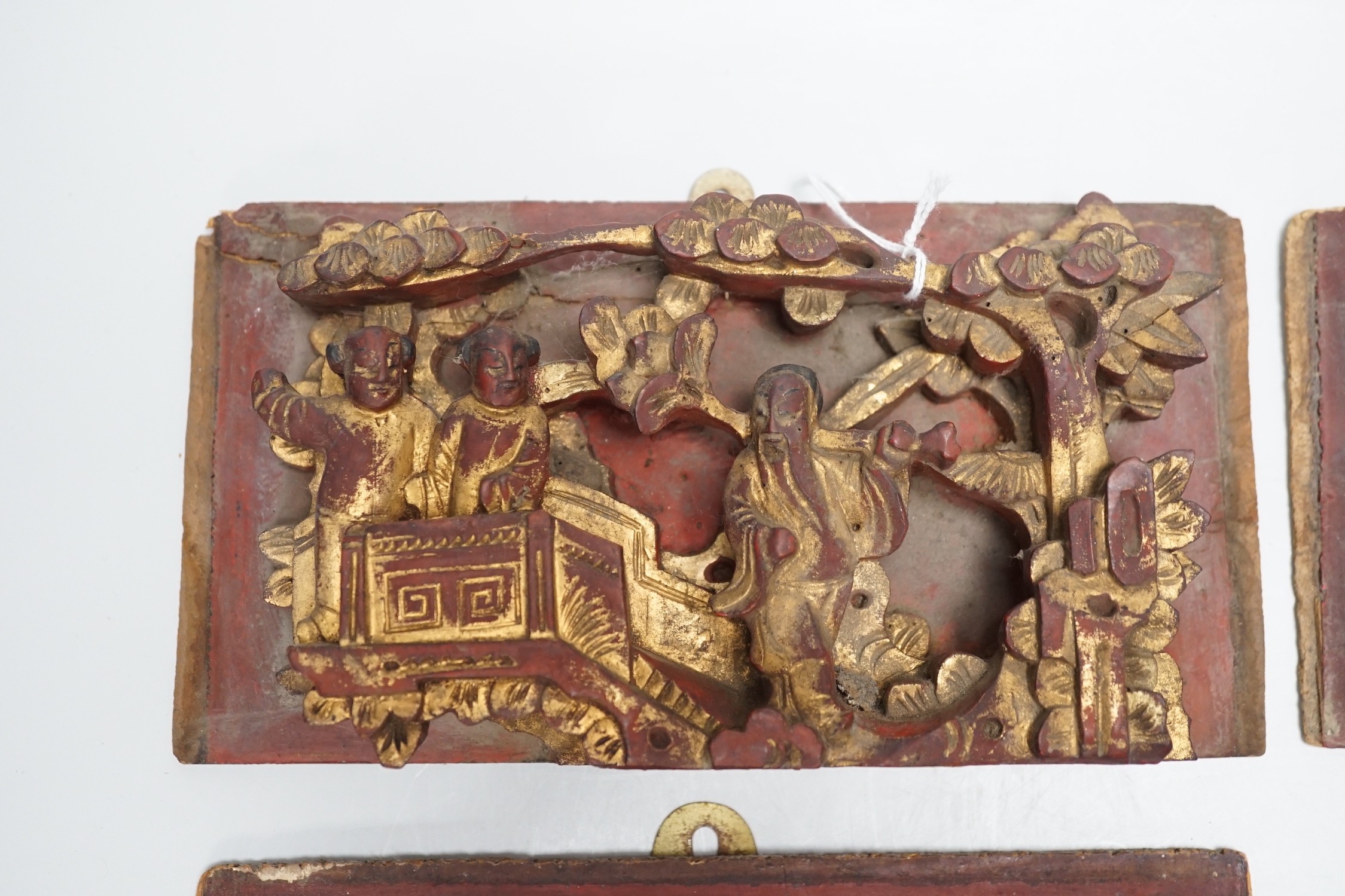 Three Chinese gilded and lacquered wood figural panels and two similar dragon and phoenix crest pieces (5), late 19th century